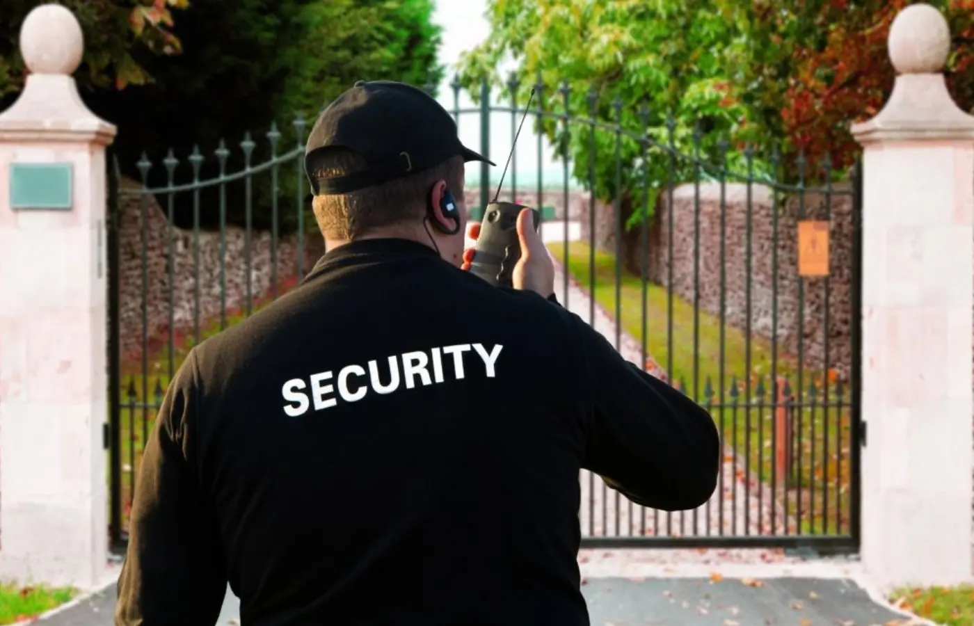 A security guard taking pictures of the gate.