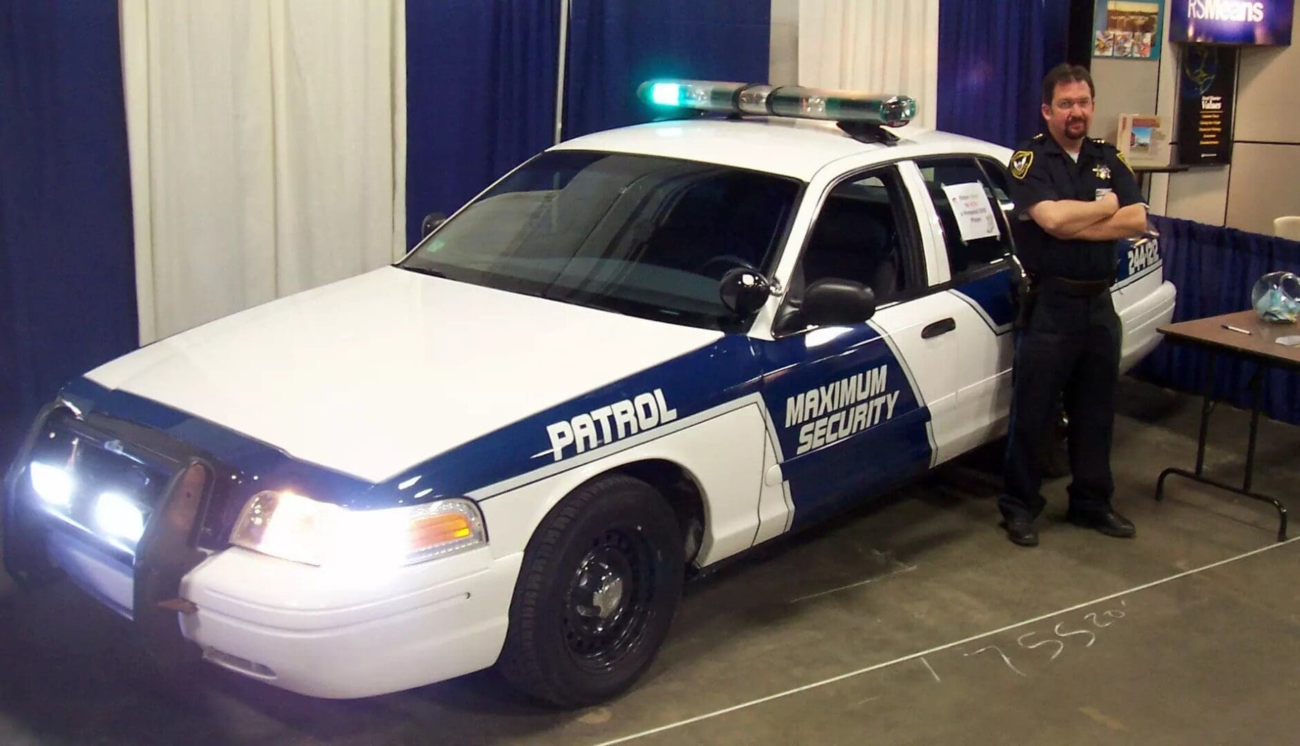 A police car with lights on parked in a garage.