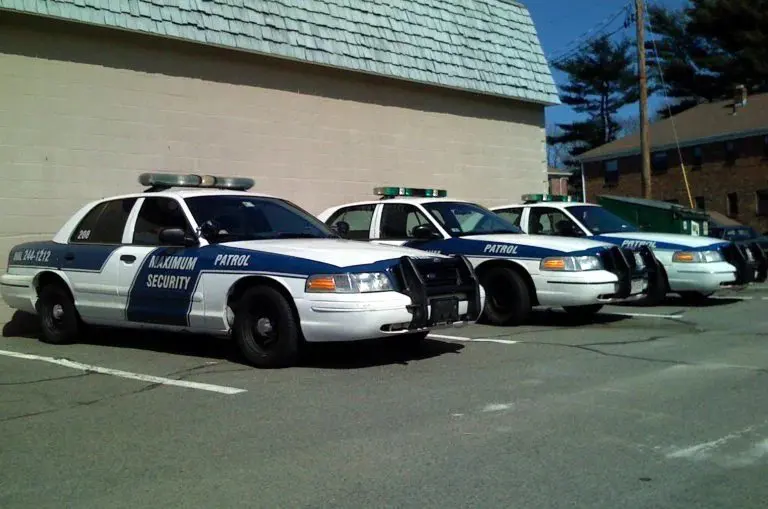 A row of police cars parked in front of a building.